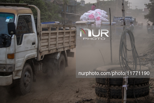 People move through a dusty, busy road in Dhaka, Bangladesh, on November 12, 2024. Dhaka, the overcrowded capital city, ranks 17th among cit...