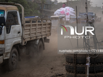 People move through a dusty, busy road in Dhaka, Bangladesh, on November 12, 2024. Dhaka, the overcrowded capital city, ranks 17th among cit...