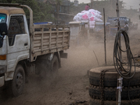 People move through a dusty, busy road in Dhaka, Bangladesh, on November 12, 2024. Dhaka, the overcrowded capital city, ranks 17th among cit...