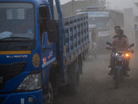 People move through a dusty, busy road in Dhaka, Bangladesh, on November 12, 2024. Dhaka, the overcrowded capital city, ranks 17th among cit...