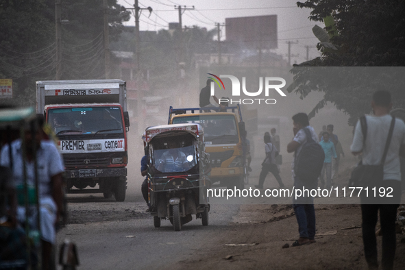 People move through a dusty, busy road in Dhaka, Bangladesh, on November 12, 2024. Dhaka, the overcrowded capital city, ranks 17th among cit...