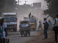 People move through a dusty, busy road in Dhaka, Bangladesh, on November 12, 2024. Dhaka, the overcrowded capital city, ranks 17th among cit...