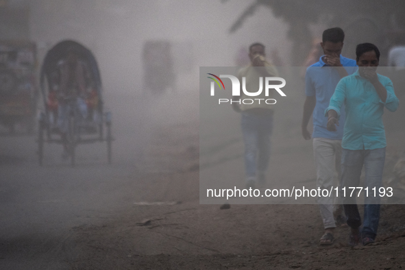 People move through a dusty, busy road in Dhaka, Bangladesh, on November 12, 2024. Dhaka, the overcrowded capital city, ranks 17th among cit...