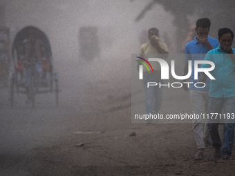 People move through a dusty, busy road in Dhaka, Bangladesh, on November 12, 2024. Dhaka, the overcrowded capital city, ranks 17th among cit...