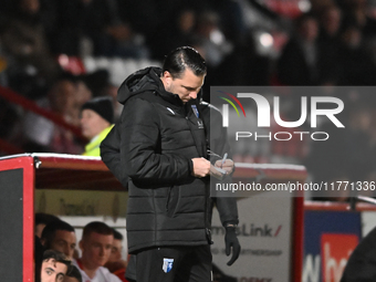 Manager Mark Bonner of Gillingham makes notes during the EFL Trophy match between Stevenage and Gillingham at the Lamex Stadium in Stevenage...