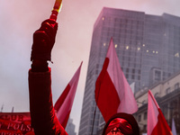 A participant carries a flare while attending Independence March celebrating the 106 anniversary of Poland regaining independence. Warsaw, P...