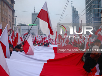 Participant carry flags while attending Independence March celebrating the 106 anniversary of Poland regaining independence. Warsaw, Poland...