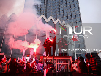 Participant hold flags and flares while attending Independence March celebrating the 106 anniversary of Poland regaining independence. Warsa...