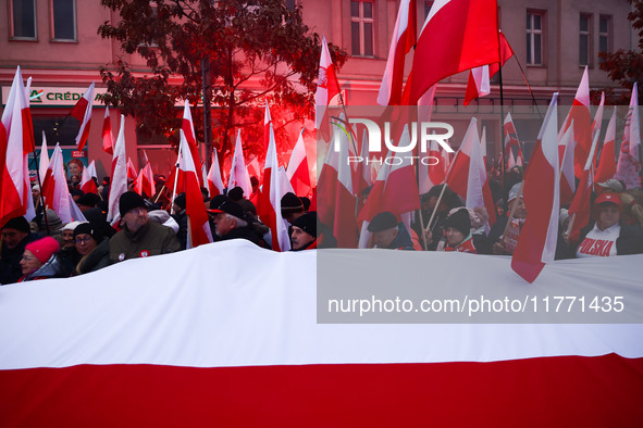 Participant carry flags while attending Independence March celebrating the 106 anniversary of Poland regaining independence. Warsaw, Poland...