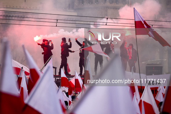 Participant hold flags and flares while attending Independence March celebrating the 106 anniversary of Poland regaining independence. Warsa...