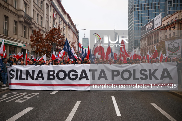 Participants carry a banner reading 'Storng Wealthy Poland' while attending Independence March celebrating the 106 anniversary of Poland reg...