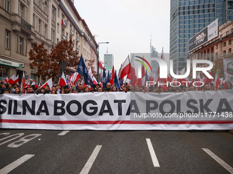 Participants carry a banner reading 'Storng Wealthy Poland' while attending Independence March celebrating the 106 anniversary of Poland reg...