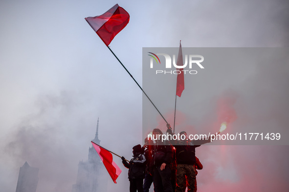 Participant hold flags and flares while attending Independence March celebrating the 106 anniversary of Poland regaining independence. Warsa...