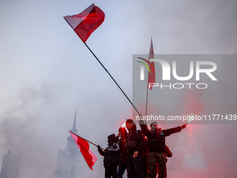 Participant hold flags and flares while attending Independence March celebrating the 106 anniversary of Poland regaining independence. Warsa...