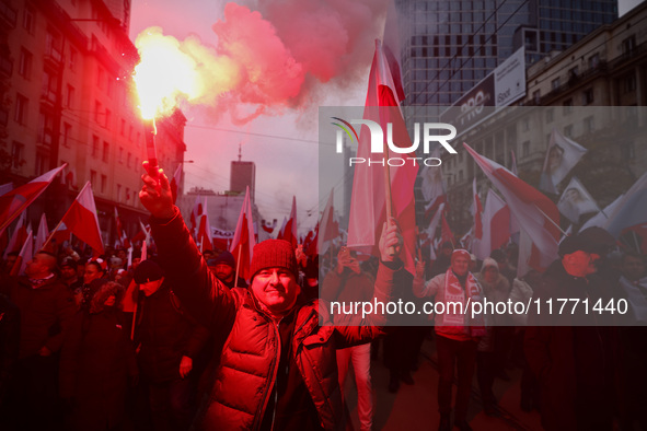 Participant hold flags and flares while attending Independence March celebrating the 106 anniversary of Poland regaining independence. Warsa...