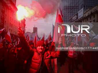 Participant hold flags and flares while attending Independence March celebrating the 106 anniversary of Poland regaining independence. Warsa...