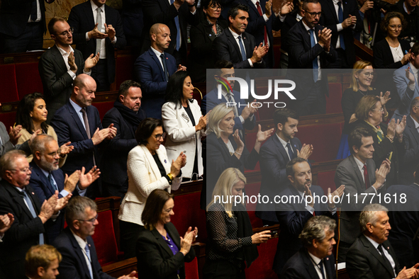 In Paris, France, on November 12, 2024, deputies of the far-right group Rassemblement National applaud the speech of Matthias Renault during...