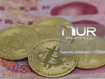 A photo taken in Huaian, China, on November 13, 2024, shows bitcoin and the Chinese yuan. (