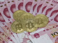 A photo taken in Huaian, China, on November 13, 2024, shows bitcoin and the Chinese yuan. (