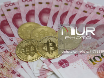 A photo taken in Huaian, China, on November 13, 2024, shows bitcoin and the Chinese yuan. (