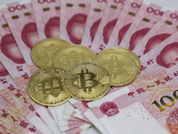 A photo taken in Huaian, China, on November 13, 2024, shows bitcoin and the Chinese yuan. (