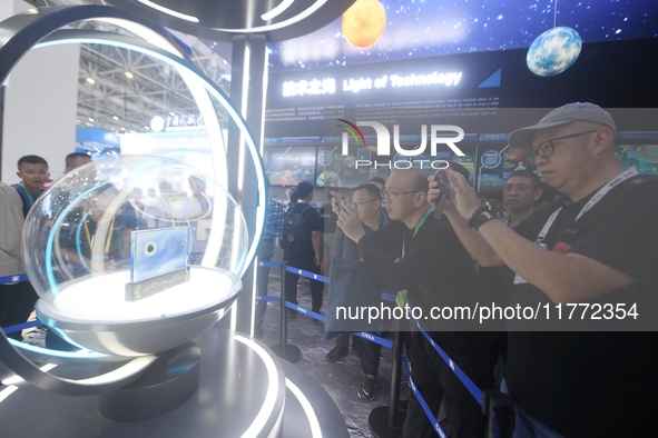 Visitors look at samples of lunar soil from the far side of the moon on display at the 2024 Zhuhai Air Show in Zhuhai, China, on November 13...