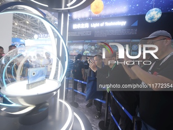 Visitors look at samples of lunar soil from the far side of the moon on display at the 2024 Zhuhai Air Show in Zhuhai, China, on November 13...