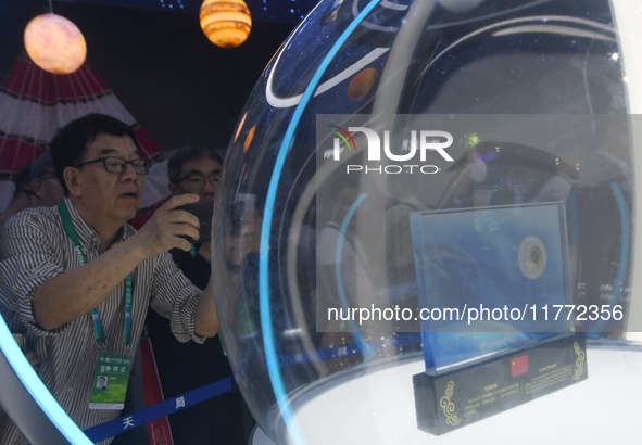 Visitors look at samples of lunar soil from the far side of the moon on display at the 2024 Zhuhai Air Show in Zhuhai, China, on November 13...