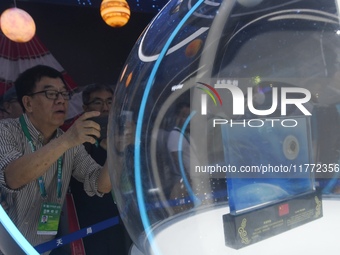 Visitors look at samples of lunar soil from the far side of the moon on display at the 2024 Zhuhai Air Show in Zhuhai, China, on November 13...