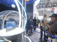 Visitors look at samples of lunar soil from the far side of the moon on display at the 2024 Zhuhai Air Show in Zhuhai, China, on November 13...