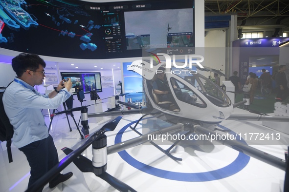 Visitors view the EH216-S electric vertical takeoff and landing unmanned manned aircraft (eVTOL) at the 2024 Zhuhai Air Show in Zhuhai, Chin...