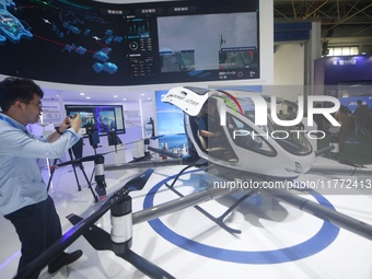 Visitors view the EH216-S electric vertical takeoff and landing unmanned manned aircraft (eVTOL) at the 2024 Zhuhai Air Show in Zhuhai, Chin...