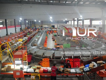 Workers of a courier company sort packages on a smart express line in Enshi, Hubei province, China, on November 13, 2024. (