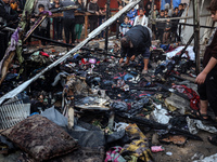 Displaced Palestinians check the damage following an Israeli strike that hits tents in Deir el-Balah in the central Gaza Strip on November 1...