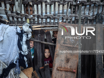 Displaced Palestinian children view the site of an Israeli strike on a tent housing displaced people in Deir el-Balah, Gaza Strip, on Novemb...