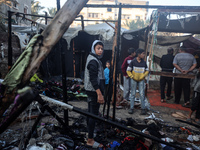 Displaced Palestinians check the damage following an Israeli strike that hits tents in Deir el-Balah in the central Gaza Strip on November 1...