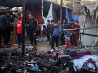 Displaced Palestinians check the damage following an Israeli strike that hits tents in Deir el-Balah in the central Gaza Strip on November 1...