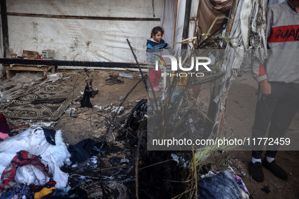 Displaced Palestinian children view the site of an Israeli strike on a tent housing displaced people in Deir el-Balah, Gaza Strip, on Novemb...