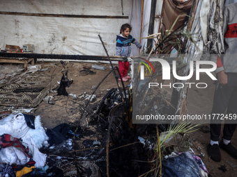 Displaced Palestinian children view the site of an Israeli strike on a tent housing displaced people in Deir el-Balah, Gaza Strip, on Novemb...