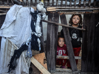 Displaced Palestinian children view the site of an Israeli strike on a tent housing displaced people in Deir el-Balah, Gaza Strip, on Novemb...