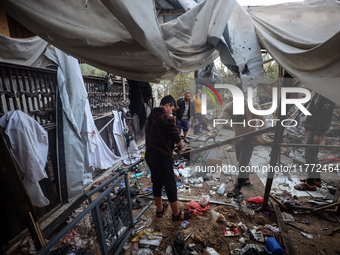 Displaced Palestinians check the damage following an Israeli strike that hits tents in Deir el-Balah in the central Gaza Strip on November 1...