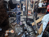 Displaced Palestinians check the damage following an Israeli strike that hits tents in Deir el-Balah in the central Gaza Strip on November 1...