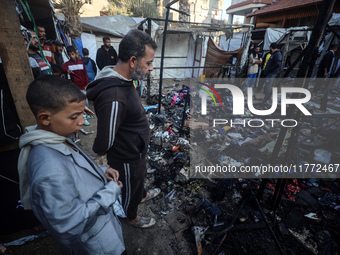 Displaced Palestinians check the damage following an Israeli strike that hits tents in Deir el-Balah in the central Gaza Strip on November 1...