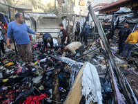 Displaced Palestinians check the damage following an Israeli strike that hits tents in Deir el-Balah in the central Gaza Strip on November 1...