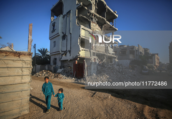 Palestinian children walk past the rubble of houses destroyed in previous strikes during the Israeli military offensive, amid the Israel-Ham...