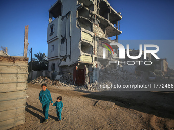 Palestinian children walk past the rubble of houses destroyed in previous strikes during the Israeli military offensive, amid the Israel-Ham...