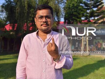 A voter shows his ink-marked finger after casting his ballot at a polling station during the Samaguri assembly constituency bypoll in Nagaon...