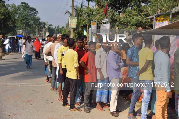 Voters wait in a queue at a polling station to cast votes during the Samaguri assembly constituency bypoll in Nagaon district, Assam, India,...