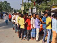 Voters wait in a queue at a polling station to cast votes during the Samaguri assembly constituency bypoll in Nagaon district, Assam, India,...