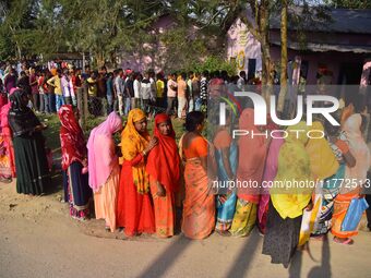 Voters wait in a queue at a polling station to cast votes during the Samaguri assembly constituency bypoll in Nagaon district, Assam, India,...